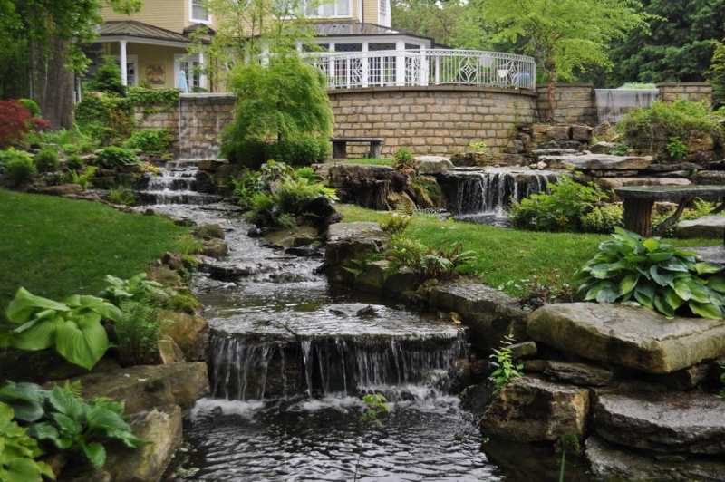 paysagiste-ASPREMONT-min_landscaping-rock-louisville-ky-traditional-landscape-and-boulders-brick-wall-bushes-grass-koi-law